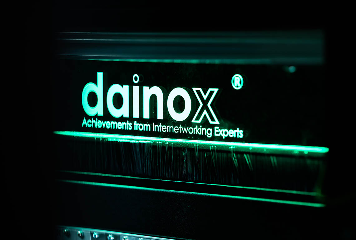 dainox Logo mit grüner LED Schrift vor schwarzem Hintergrund